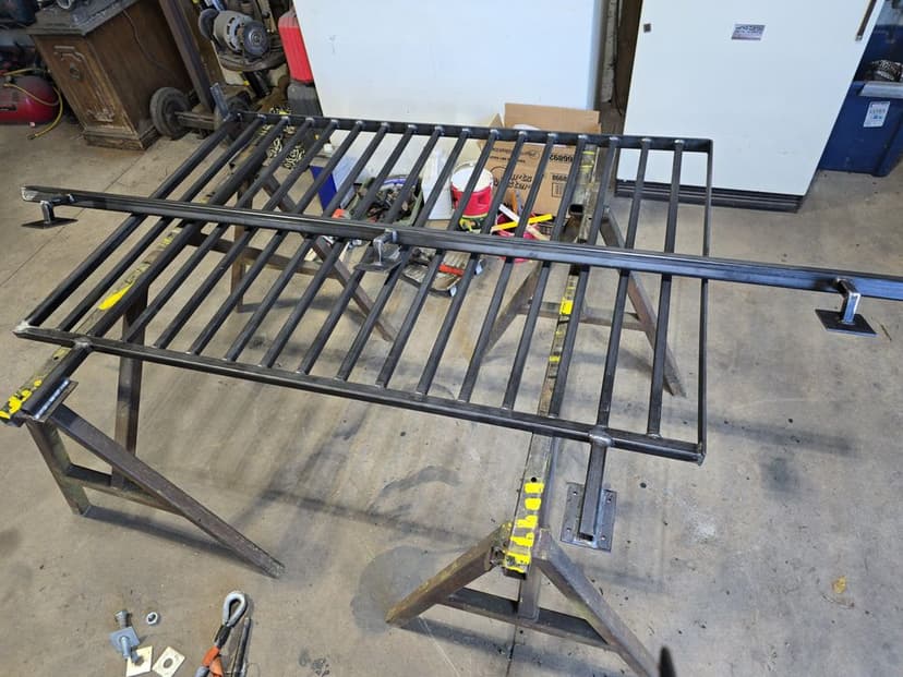 Metal framework on workbench with clamps and tools in a workshop setting.